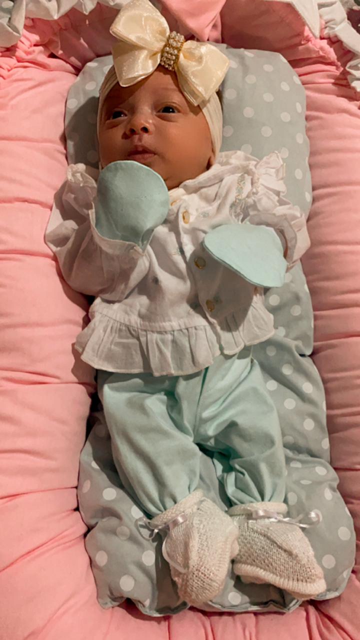 Foto de referência: bebê Liz Maria com laço dourado e roupinha azul de poás, 2 meses de vida